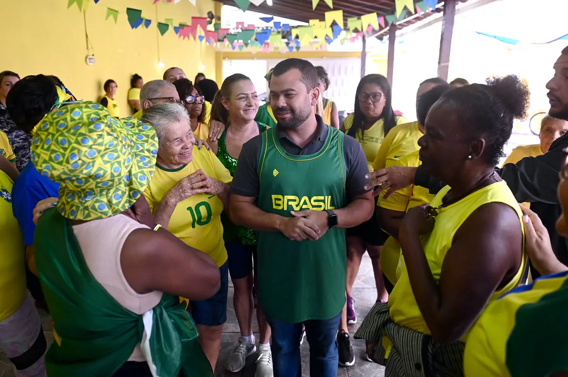 Felipe Pampolha cercado por um grupo de senhoras vestidas de verde e amarelo.